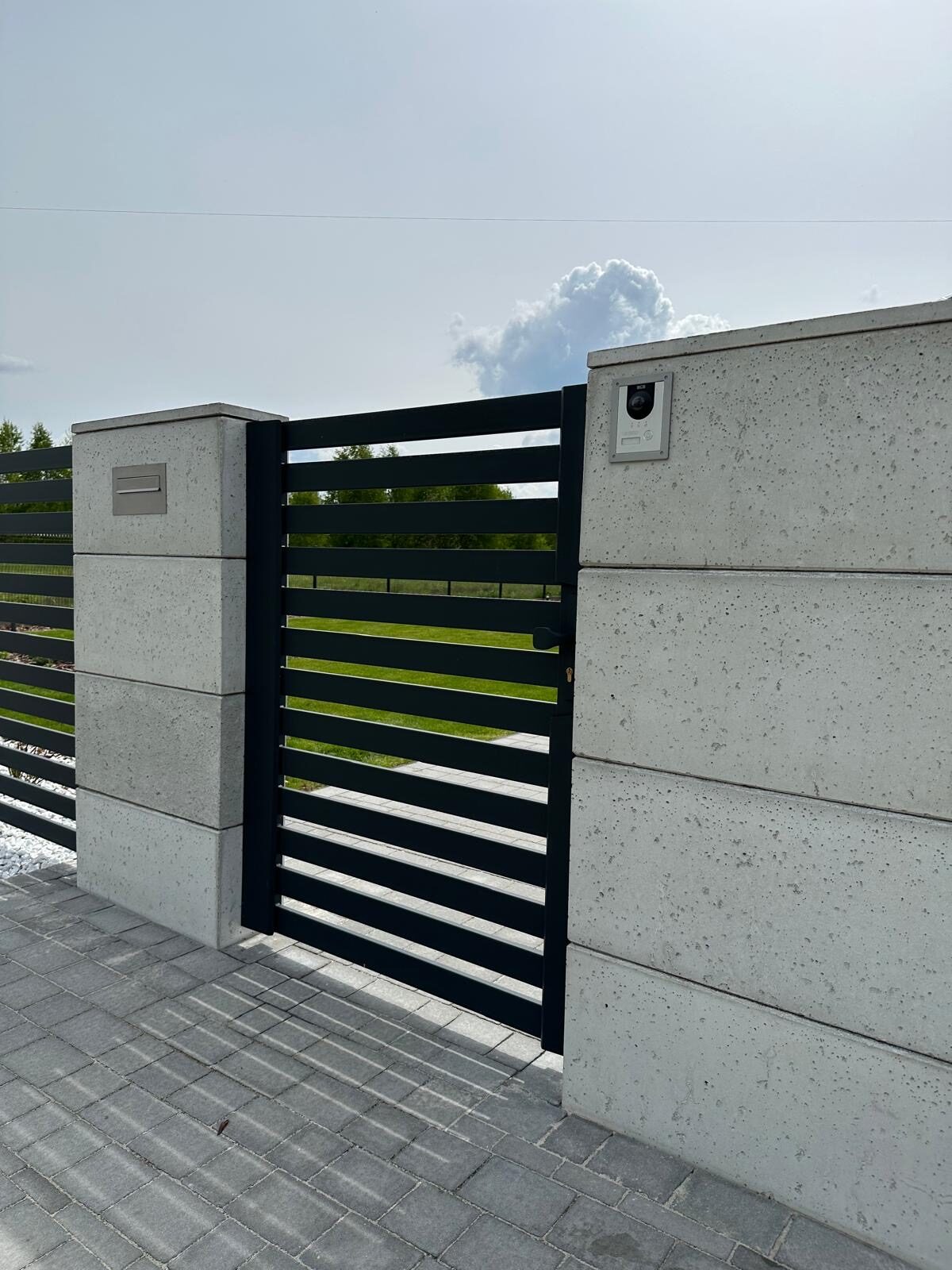 Furtka z poziomym wypełnieniem między słupkami z betonu architektonicznego